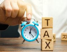 businessman-s-hand-holding-a-clock-near-the-wooden-2026-03-24-02-22-53-utc